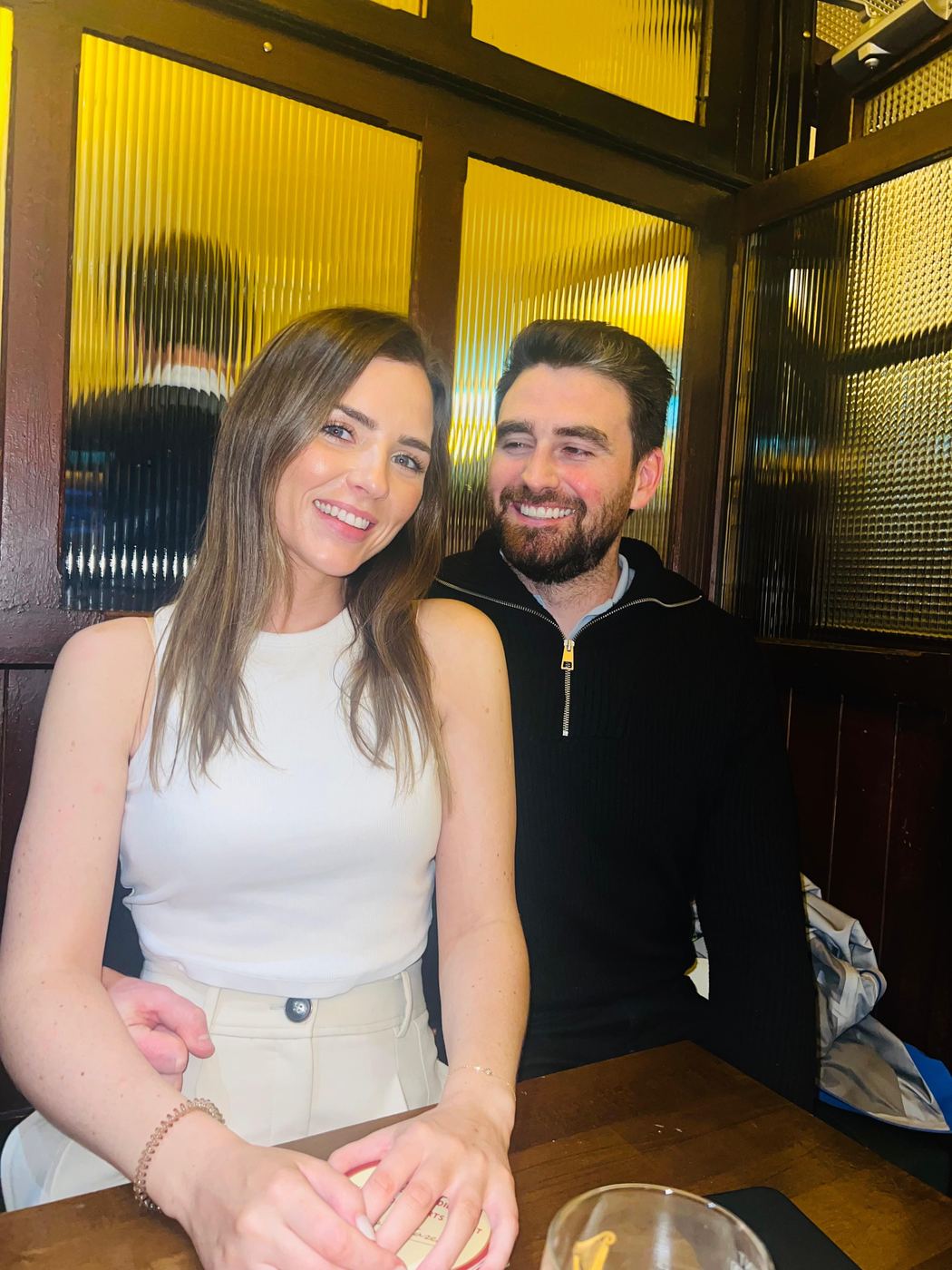 Jack and Niamh smiling together at a pub table